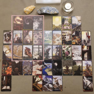 Lenormand Grand Tableau mid-reading - two cards have been moved to above the top row to form a 9 square around the woman card and the wild card.